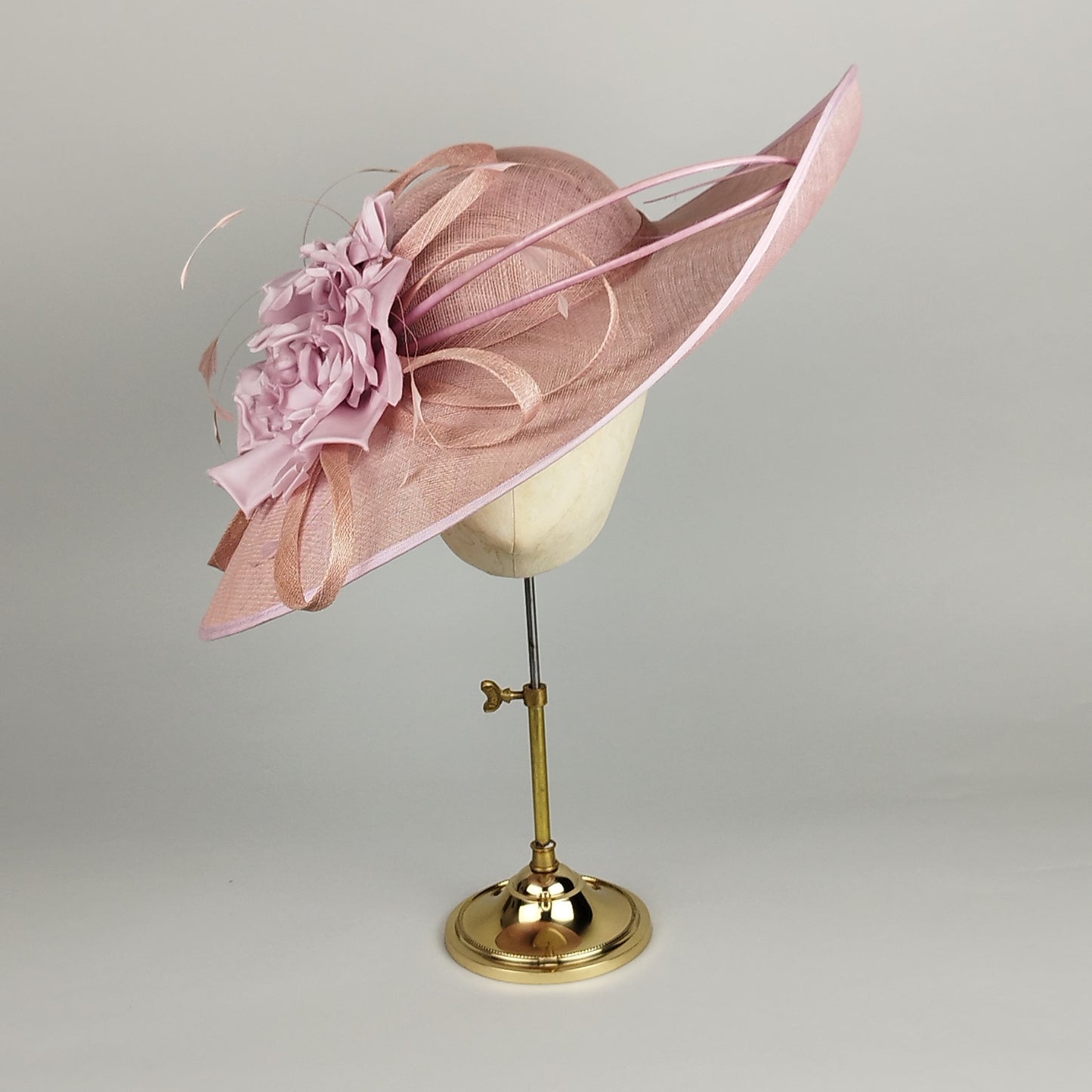 Blush pink wedding hat with hand-made silk flowers, sinamay loops, and feather accents. Perfect hat for Royal Ascot or the mother of the bride. A bold yet refined wide brim hat.
