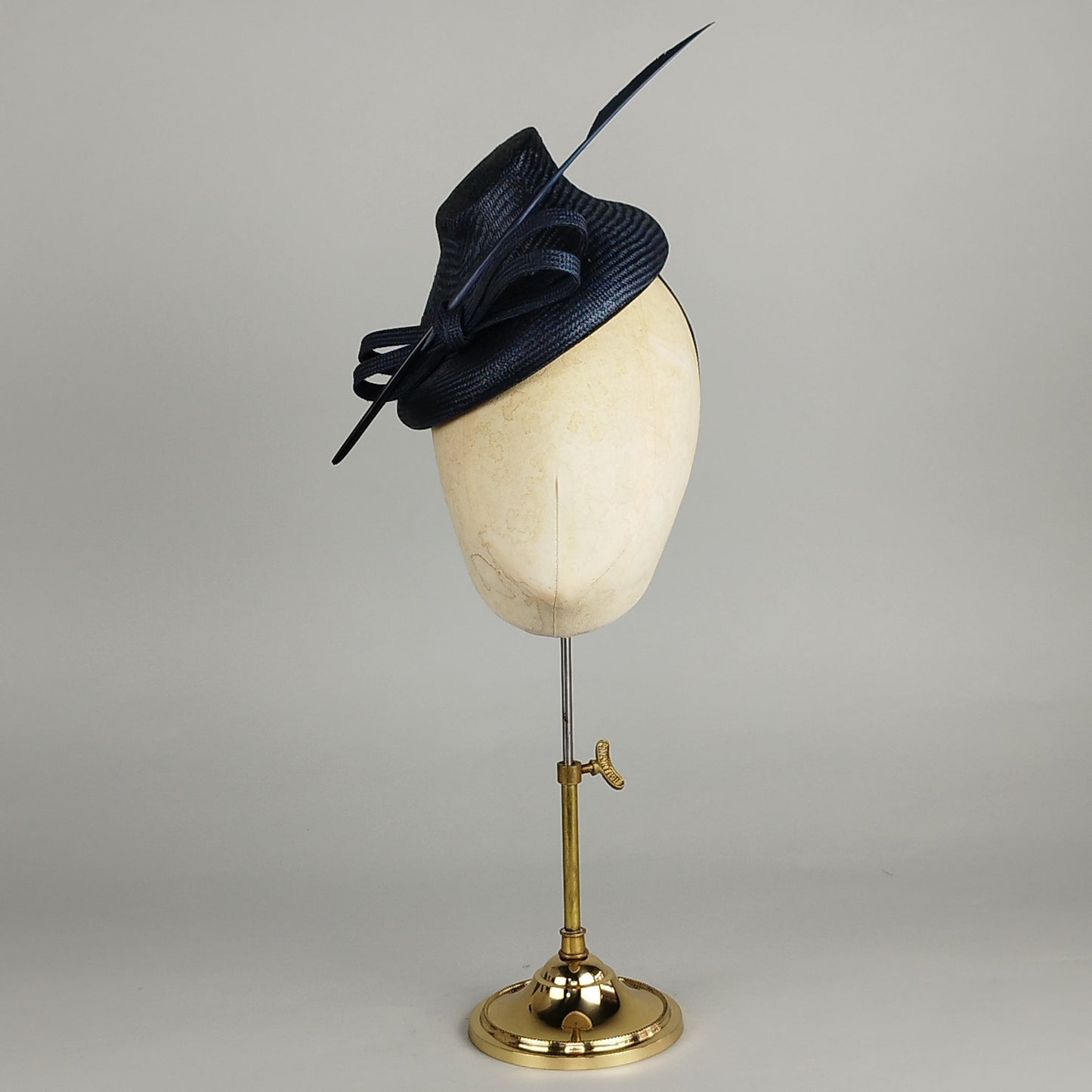 Sleek Navy fascinator with bow trim and shooting arrow feather, perfect for Royal Ascot and weddings.