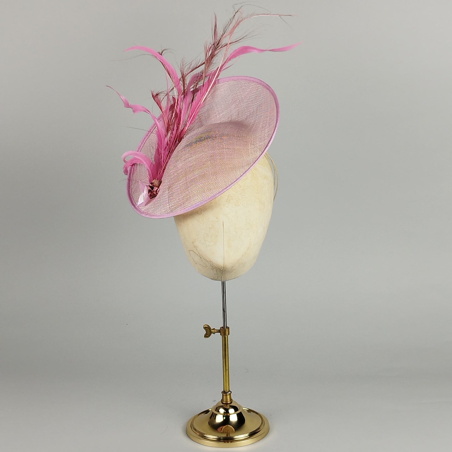 Candy pink fascinator with pink feathers, sequins, and a modern design, perfect for weddings or race day.