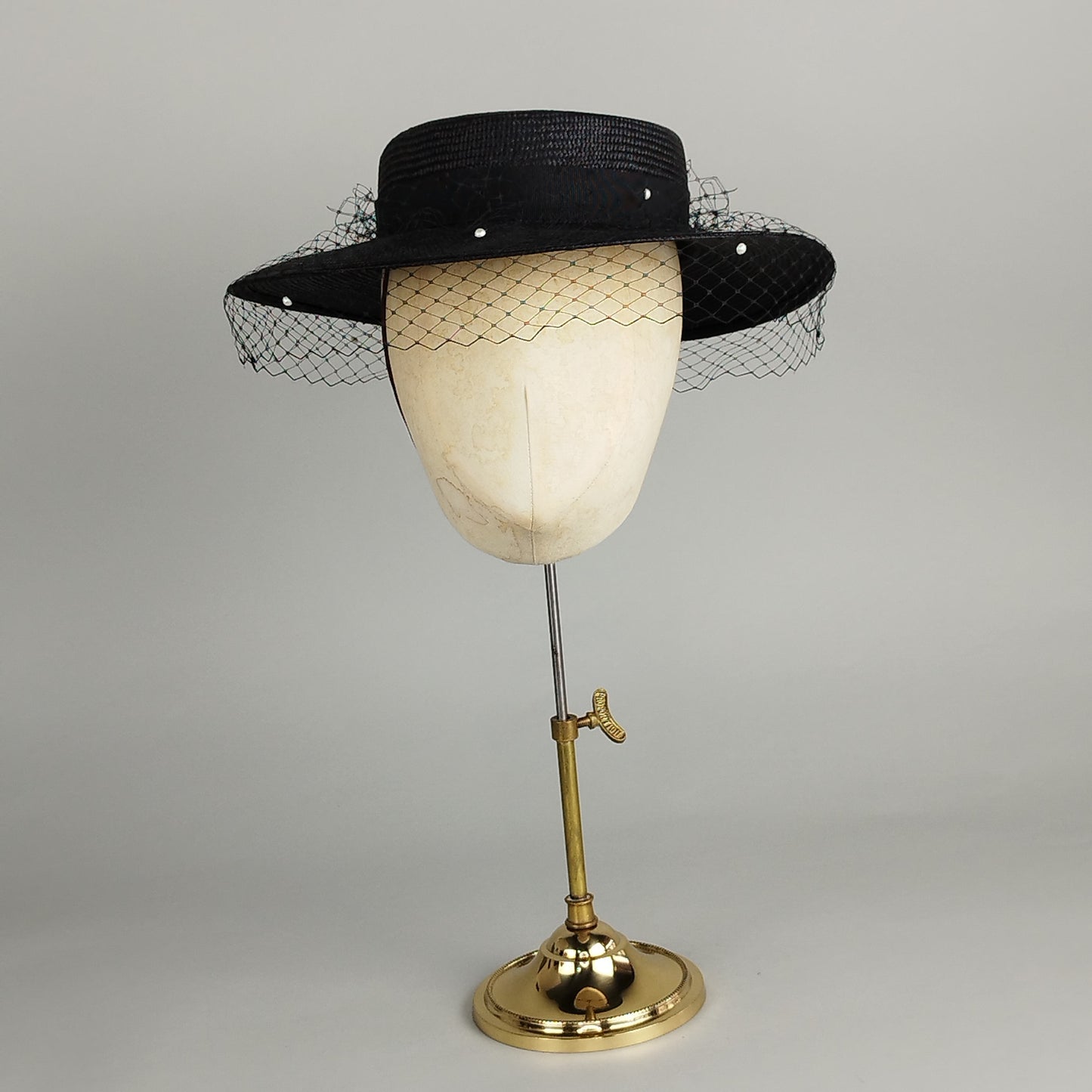 Black straw boater hat with pearl veil and hat pins, offering chic sophistication for weddings and special occasions.