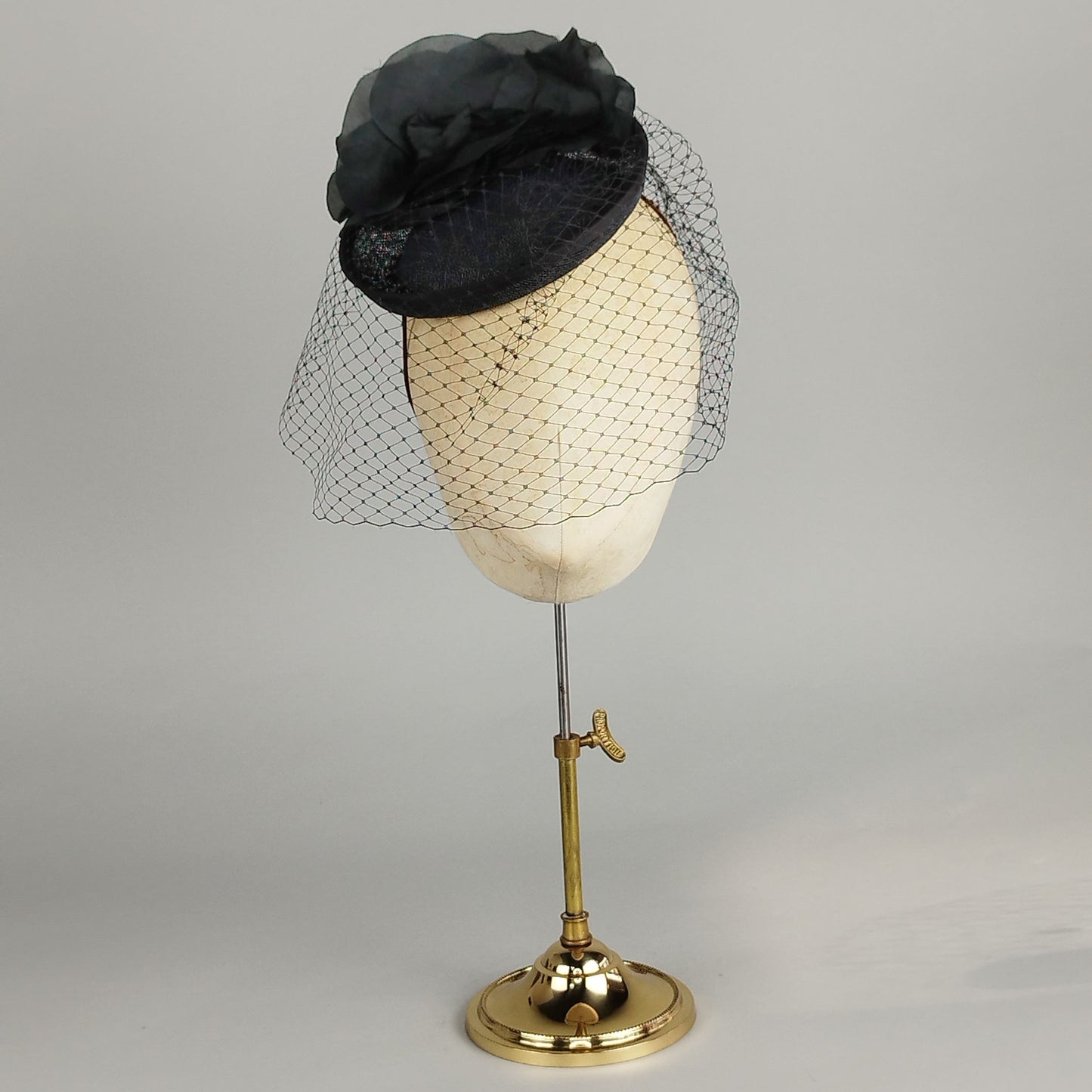 Black fascinator with silk and rose and birdcage veil, perfect for weddings and Royal Ascot.