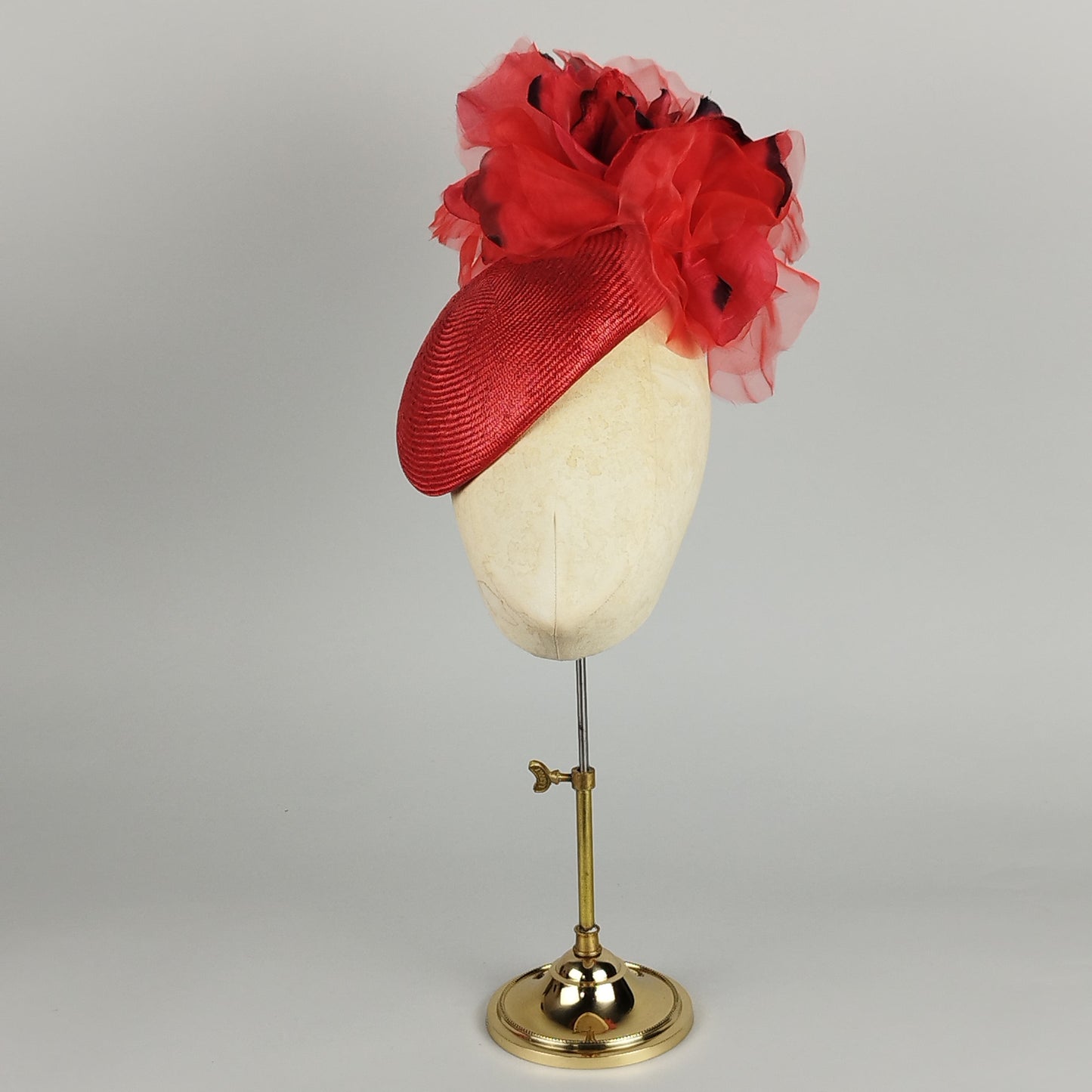 Red fascinator with black accents and chiffon flowers, perfect for weddings and Royal Ascot.