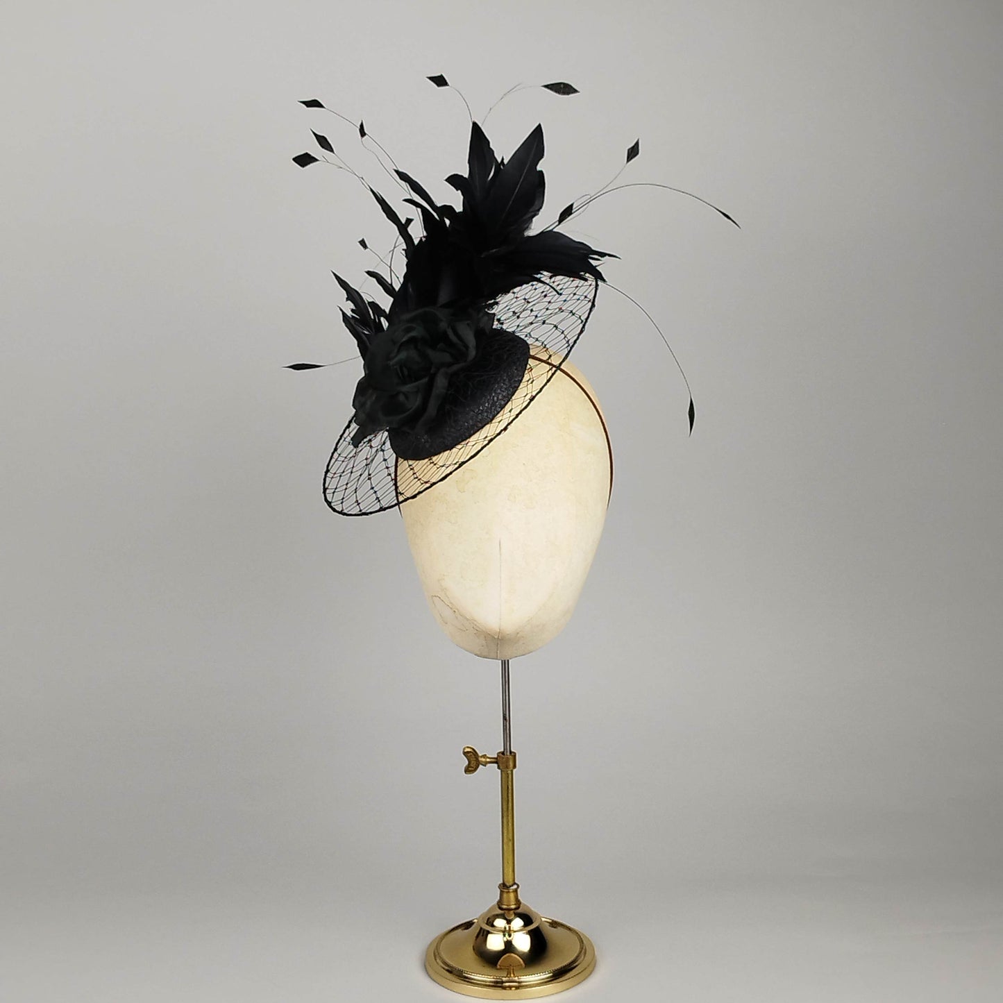 Black pillbox fascinator with dramatic feathers and circular birdcage veil