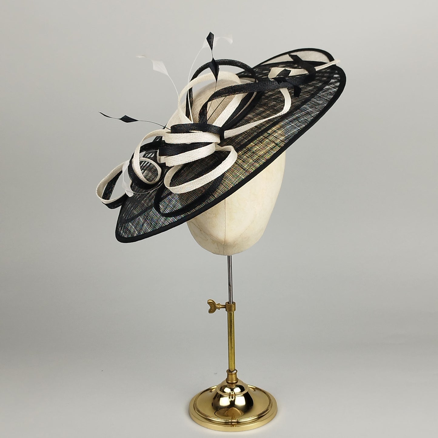 Black and White fascinator with graphic woven sinamay, sinamay swirls, and dramatic feathers.