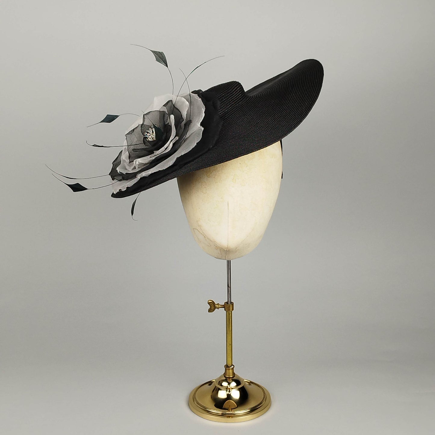 Black vintage-inspired mini boater hat with dramatic black and White flower and feather detail