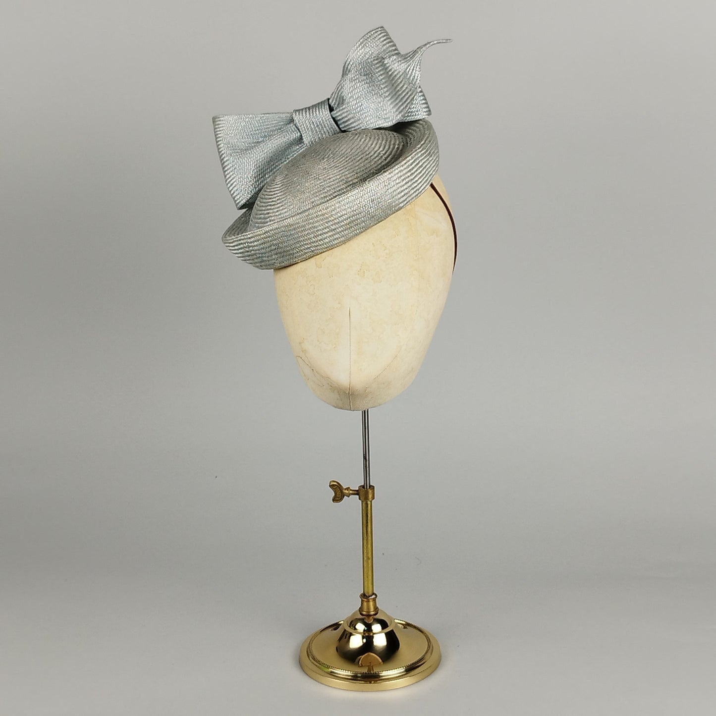 Pale blue pillbox hat with structured bow, perfect for weddings and high-fashion events.
