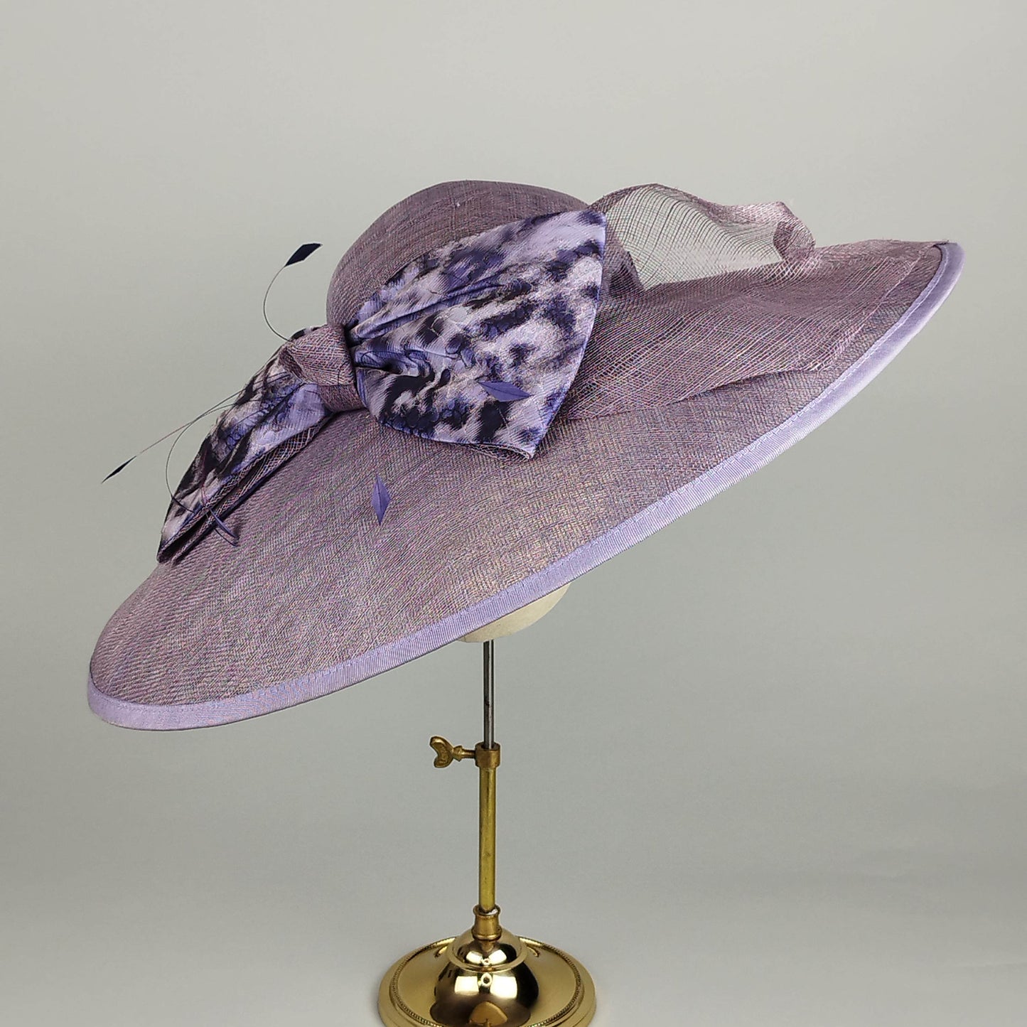 Purple wide-brim hat with bow decoration, perfect for weddings, Royal Ascot, and race days.