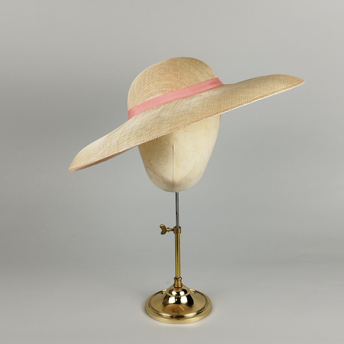 Soft salmon pink wedding hatinator with wide brim and blush ribbon – elegant and timeless.