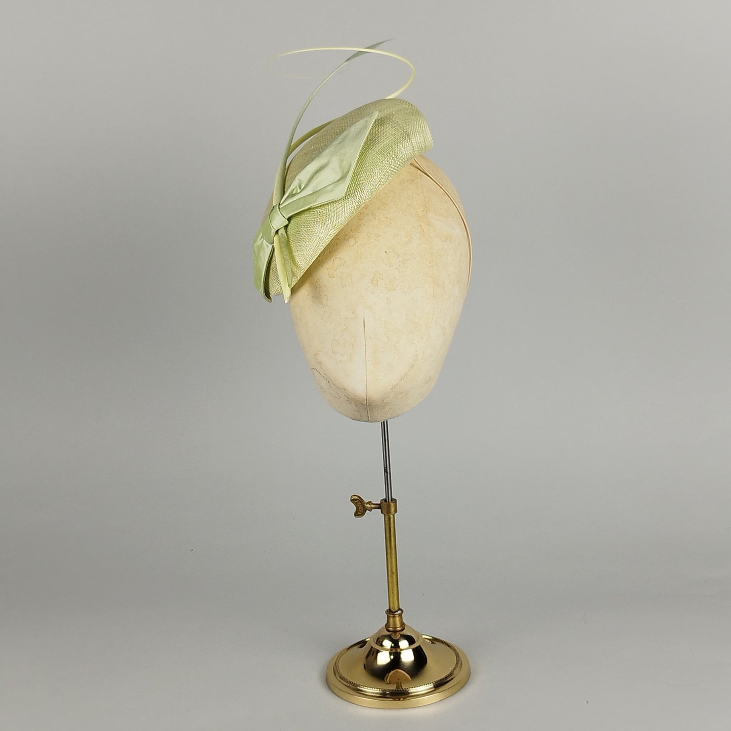 Pastel green fascinator with feather flower and quill, perfect for weddings, race days, and special occasions.