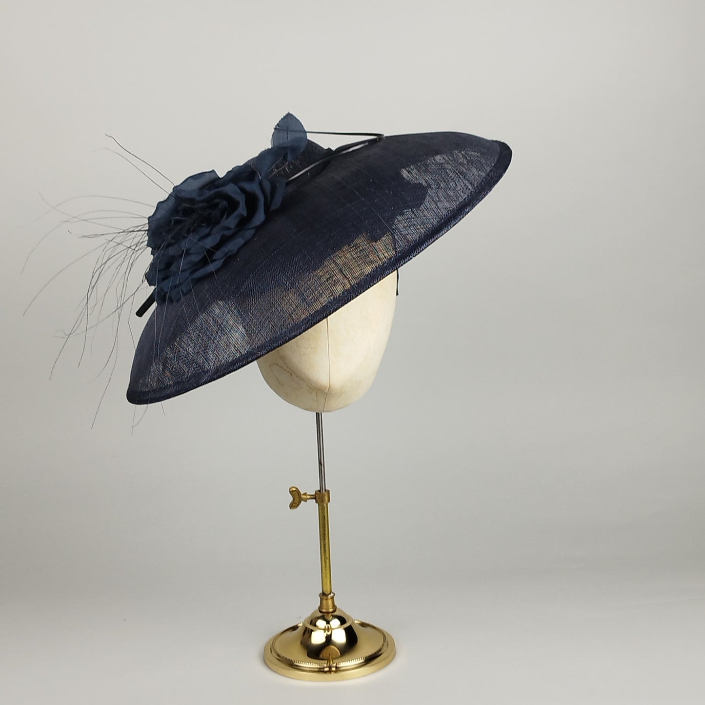 Navy fascinator hat with silk flowers and feathers for a sophisticated, 50s inspired look.