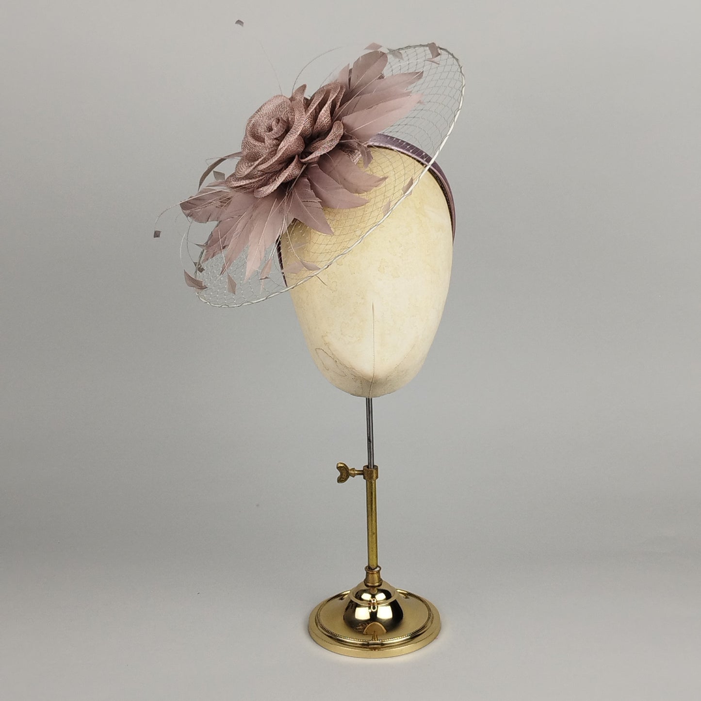Taupe fascinator with floral detail and circular veiling on headband