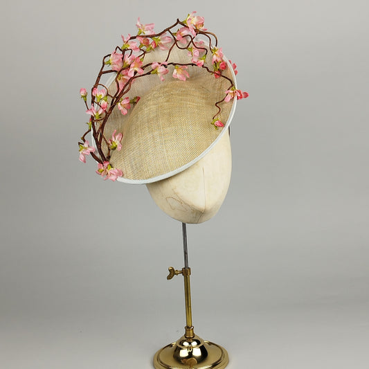 Neutral saucer hat with duck egg blue trim and pink cherry blossom flowers, perfect for weddings or spring events.