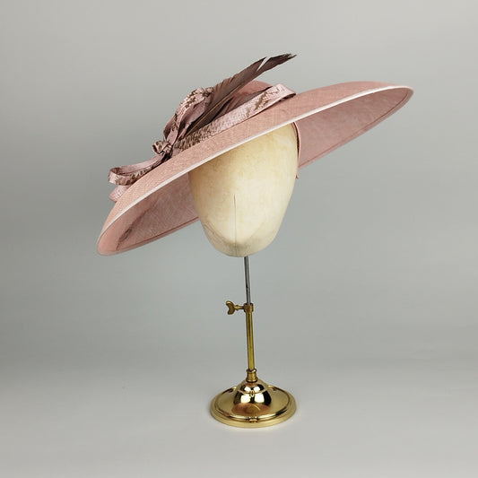 Dusty rose pink hat with slanted brim and imitation snake skin trim. A striking statement piece for Royal Ascot, garden weddings, and special occasions. Deep mocha feathers complete the look.