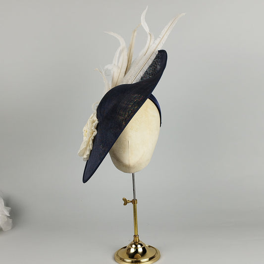 Navy hatinator with ivory pleated flower and twirling ostrich feathers, perfect for weddings and Royal Ascot.