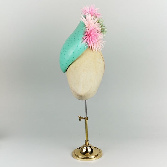 Turquoise ostrich leather base with pink and turquoise spiky feathers, perfect for fun, bold occasions like weddings and garden parties.