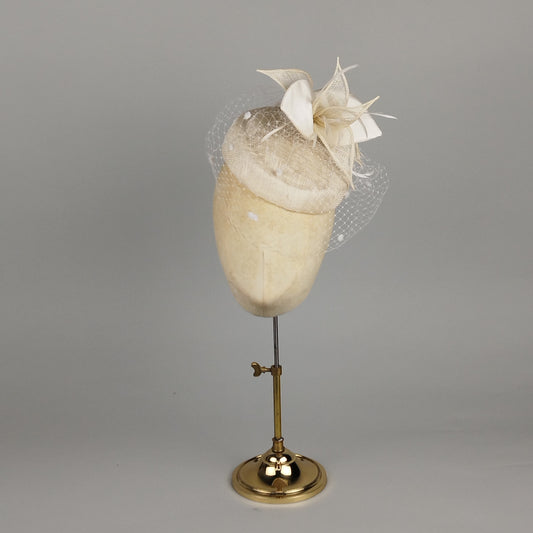 Ivory pillbox hat with birdcage veil and sculptural flower detail