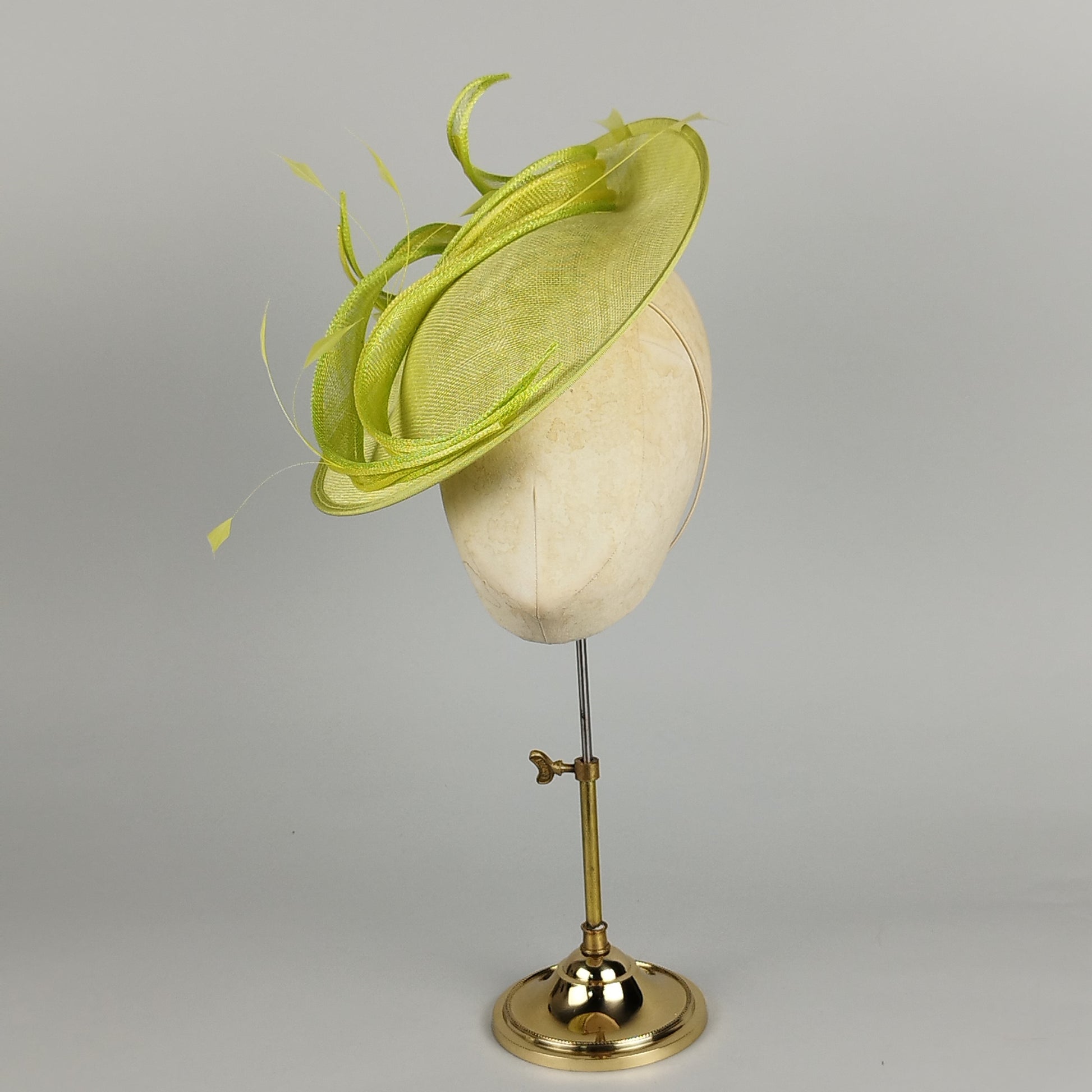 Fresh lime green and lemon yellow hatinator with sinamay swirls and feather accents, perfect for weddings and special occasions