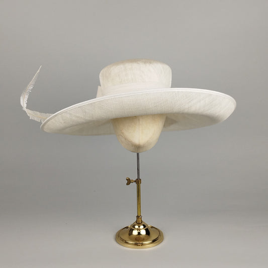 Ivory hat with feather and soft bow detail. Elegant hat for hire.