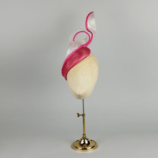 Hot pink fascinator with mermaid shimmer crinoline swirl and pink streaks, perfect for weddings or Royal Ascot. Fun and playful elegance.
