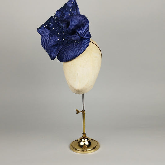 Navy blue fascinator in straw with double-bow, pearls, and lace – dramatic and sophisticated.