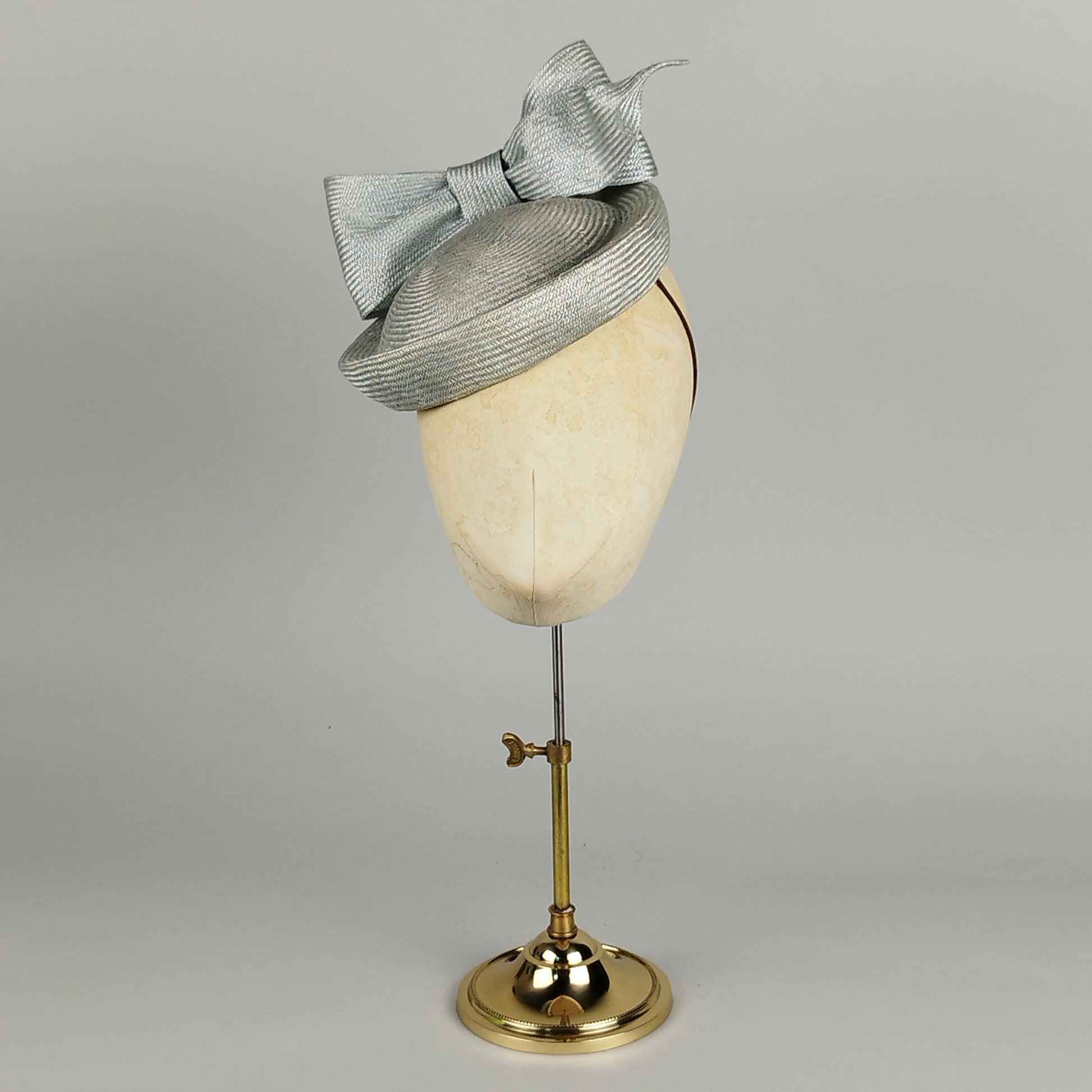 Pale blue pillbox hat with structured bow, perfect for weddings and high-fashion events.