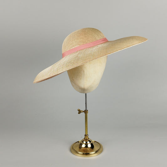 Soft salmon pink wedding hatinator with wide brim and blush ribbon – elegant and timeless.