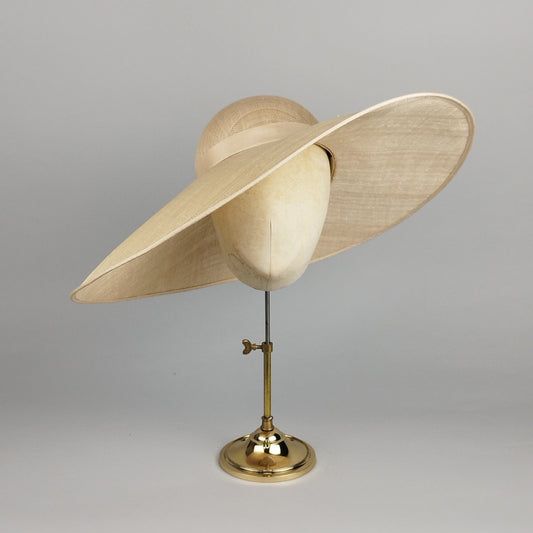 Wide brim champagne asymmetrical hat with dramatic sculptural silhouette