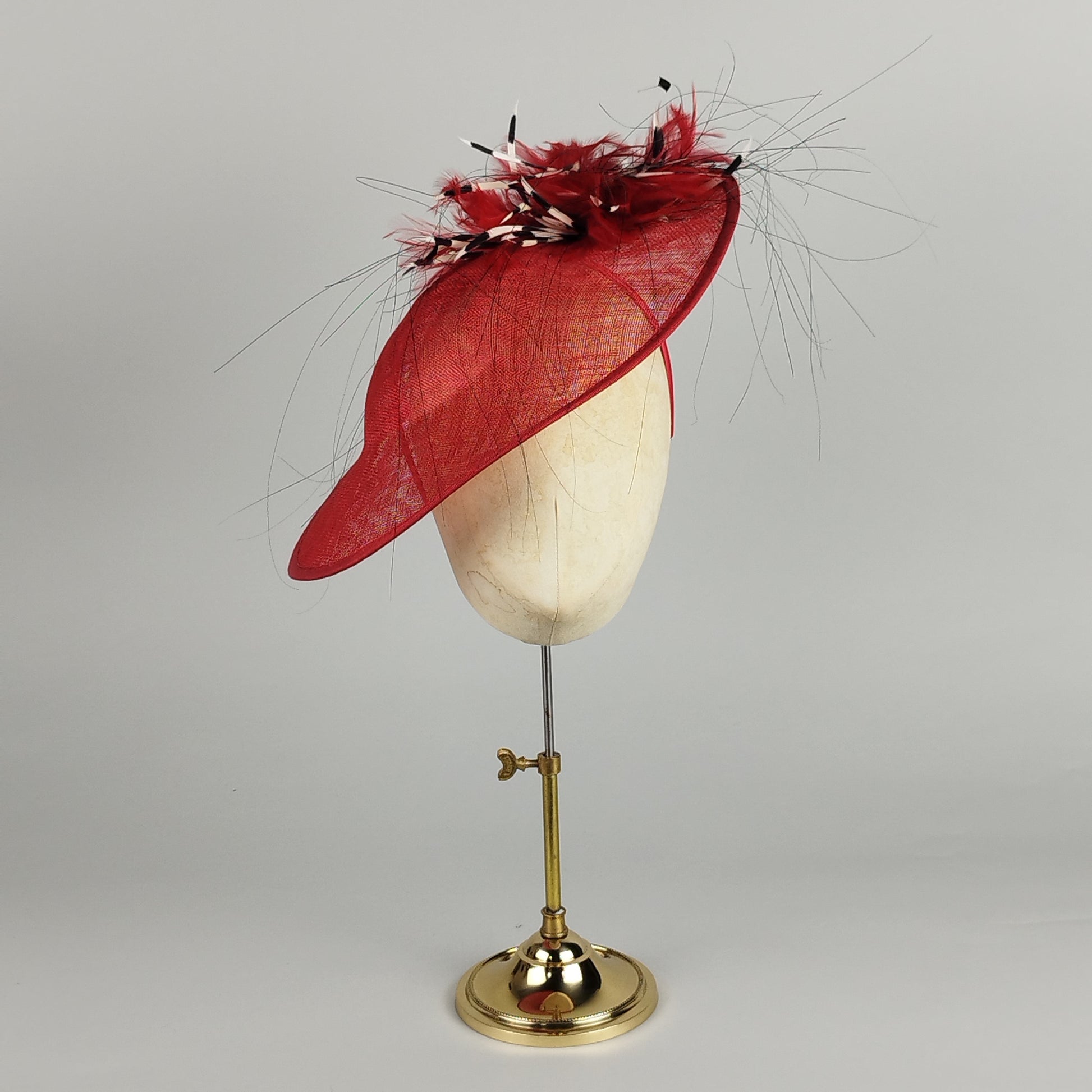Bold red feathered hatinator with red, black, and White feathers. Perfect for weddings, Ascot, or special events. Playful and elegant.