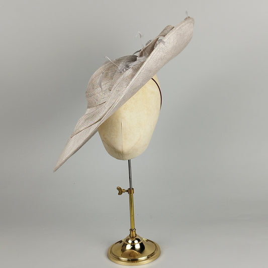 Pale grey silver wedding hat with sweeping brim, feathers, and bow – elegant and dramatic