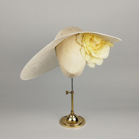White asymmetric hat with yellow flower accent for sophisticated occasion wear