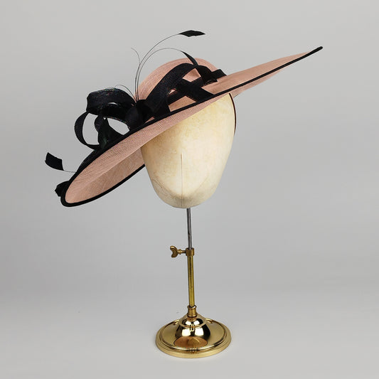 Pale pink and black hatinator with loops, swirls, and feathers – chic and bold